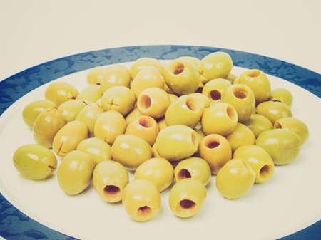 Vintage looking Picture of Green olives over a white backgroundの写真素材