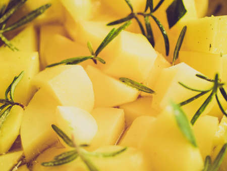 Vintage looking Potatoes with rosemary vegetarian food backgroundの写真素材