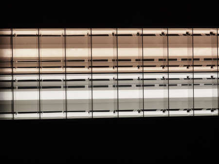 Lit neon lights over dark black backgroundの写真素材