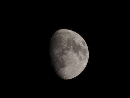 Waxing gibbous moon over dark sky at nightの写真素材