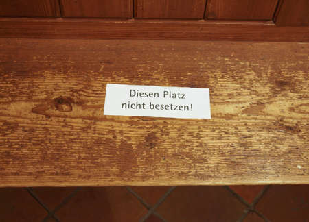 Diesen platz nicht besetzen meaning Do not sit here warning sign written on a wooden seat