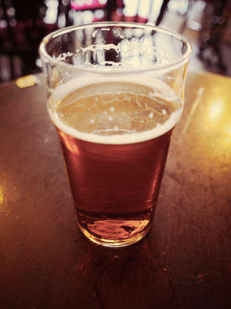 Vintage looking pint of English bitter ale in a pub