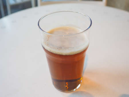 Pint of British ale on a pub table - selective focus on beer over blurred backgroundの写真素材