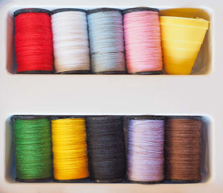 Travel sewing kit including thread spools of many different colours and thimble