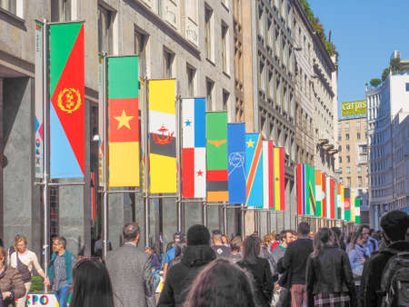 MILAN, ITALY - MARCH 28, 2015: Tourists walking by the flags from all countries of the world on show in Milan city centre as part of the Expo Milano 2015 international exhibitionのeditorial素材