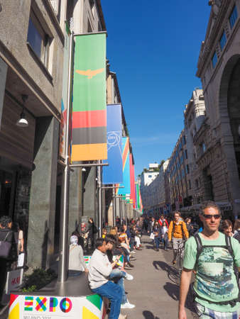 MILAN, ITALY - MARCH 28, 2015: Tourists walking by the flags from all countries of the world on show in Milan city centre as part of the Expo Milano 2015 international exhibitionのeditorial素材