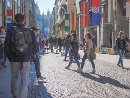 MILAN, ITALY - MARCH 28, 2015: Tourists walking by the flags from all countries of the world on show in Milan city centre as part of the Expo Milano 2015 international exhibitionのeditorial素材