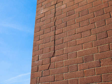 Crack in a brick wall caused by excessive settling due to bad foundations or too much load or earthquakeの写真素材