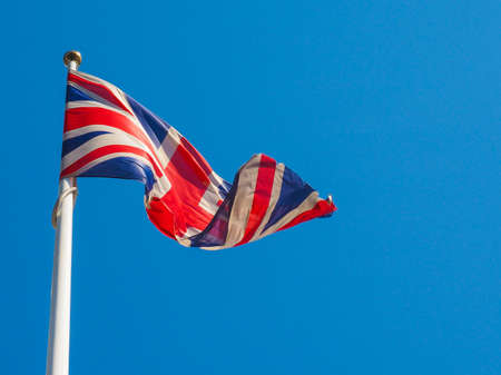 The national flag of United Kingdom, Europe floating in the wind over blue skyの写真素材