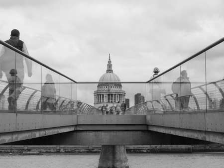 LONDON, UK - JUNE 10, 2015: People crossing the Millennium Bridge linking the City of London with the South Bank between St Paul Cathedral and Tate Modern art gallery in black and whiteのeditorial素材