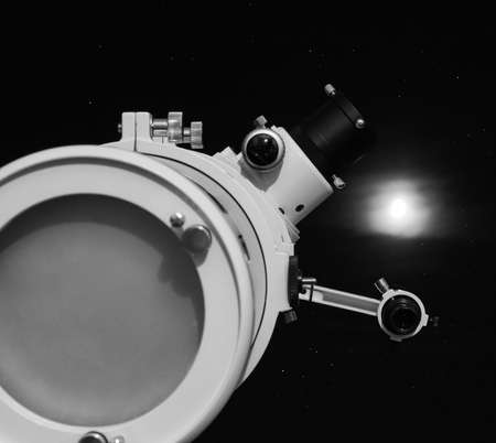 Astronomical telescope over dark sky with the moon - selective focus on telescope in black and whiteの写真素材