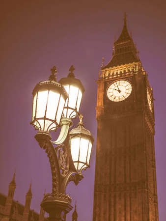 Vintage looking Big Ben at the Houses of Parliament aka Westminster Palace at night in London, UK