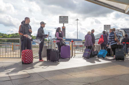 STANSTED, UK - SEPTEMBER 24, 2015: Travellers waiting for tranport at London Stansted airport coach...