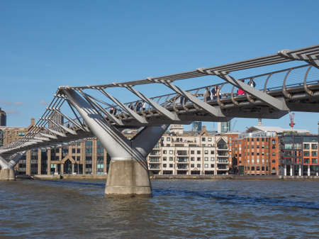 LONDON, UK - SEPTEMBER 28, 2015: People crossing the Millennium Bridge over River Thames linking the City of London with the South Bank between St Paul Cathedral and Tate Modern art galleryのeditorial素材