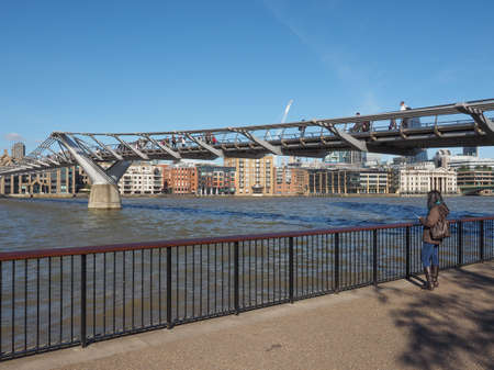LONDON, UK - SEPTEMBER 28, 2015: People crossing the Millennium Bridge over River Thames linking the City of London with the South Bank between St Paul Cathedral and Tate Modern art galleryのeditorial素材