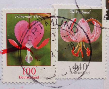 BERLIN, GERMANY - OCTOBER 5, 2015: Two stamps printed by Germany mail service show flowersのeditorial素材