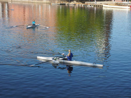STRATFORD UPON AVON, UK - SEPTEMBER 26, 2015: People canoeing paddling a canoe with a single bladed paddle in River Avonのeditorial素材