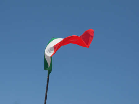 The national flag of Italy, Europe floating over blue skyの写真素材