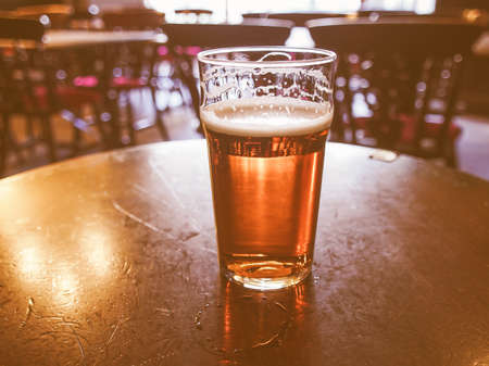 Vintage looking A pint of English ale beer in a pubの写真素材