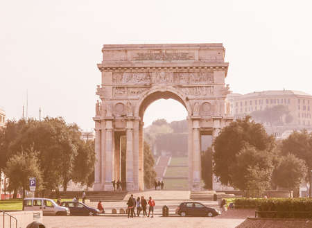 GENOA, ITALY - MARCH 16, 2014: Tourists visiting Arco della Vittoria marble arch which was designed by Marcello Piacentini in 1924 as part of Piazza della Vittoria redesign vintageのeditorial素材