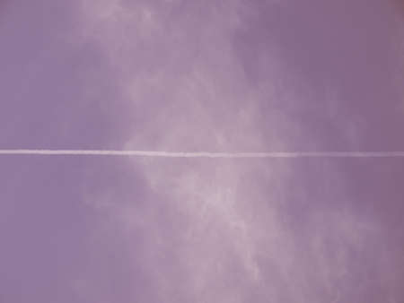 Blue sky with plane trail and white clouds useful as a background vintageの写真素材