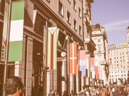 MILAN, ITALY - MARCH 28, 2015: Tourists walking by the flags from all countries of the world on show in Milan city centre as part of the Expo Milano 2015 international exhibition vintageのeditorial素材