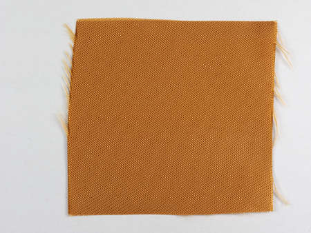 Golden fabric swatch over white backgroundの写真素材