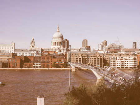 LONDON, UK - SEPTEMBER 28, 2015: People crossing the Millennium Bridge over River Thames linking the City of London with the South Bank between St Paul Cathedral and Tate Modern art gallery vintageのeditorial素材