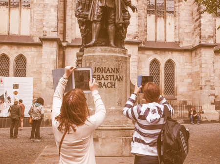 LEIPZIG, GERMANY - JUNE 14, 2014: Women photographing the Neues Bach Denkmal Bach monument with a tablet pc vintageのeditorial素材