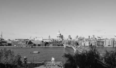 LONDON, UK - SEPTEMBER 28, 2015: People crossing the Millennium Bridge over River Thames linking the City of London with the South Bank between St Paul Cathedral and Tate Modern art gallery in black and whiteのeditorial素材