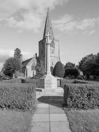 TANWORTH IN ARDEN, UK - SEPTEMBER 25, 2015: The Village Green with St Mary Magdalene church and war memorial in black and whiteのeditorial素材