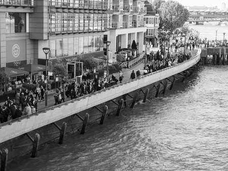 LONDON, UK - SEPTEMBER 29, 2015: Tourists walking on the River Thames South Bank in black and whiteのeditorial素材