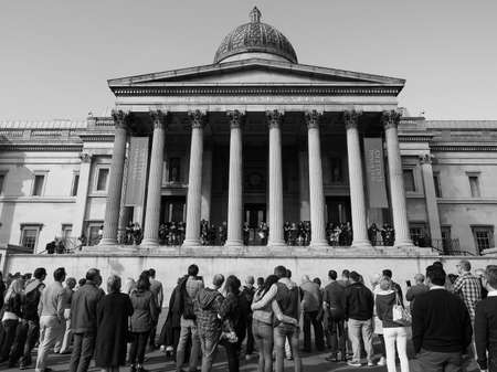 LONDON, UK - SEPTEMBER 27, 2015: Tourists in Trafalgar Square in front of the National Gallery in black and whiteのeditorial素材