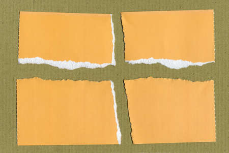 Yellow Paper torn in many pieces over corrugated cardboard background