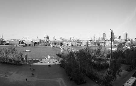 LONDON, UK - SEPTEMBER 28, 2015: People crossing the Millennium Bridge over River Thames linking the City of London with the South Bank between St Paul Cathedral and Tate Modern art gallery in black and whiteのeditorial素材
