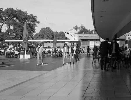 LONDON, UK - SEPTEMBER 29, 2015: Tourists walking on the River Thames South Bank in black and whiteのeditorial素材