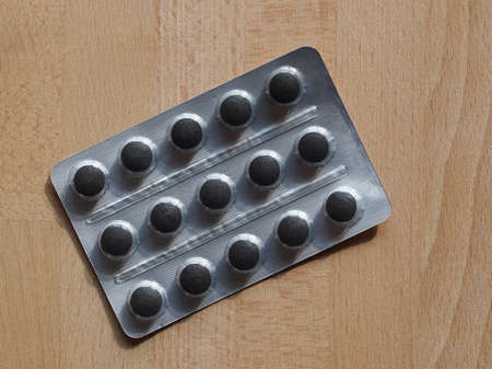Pharmaceutical over the counter or prescription pills, flat lay on wooden desk