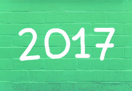 Year 2017 written on green brick wall background