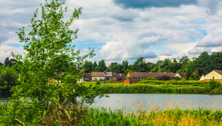High dynamic range (HDR) English countryside seen from a train to London, with selective focus on the horizon and motion blur on the foregroundの写真素材