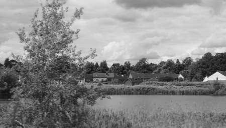 English countryside seen from a train to London, with selective focus on the horizon and motion blur on the foreground in black and whiteの写真素材