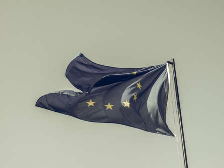 Vintage looking The national flag of European Union floating over blue sky