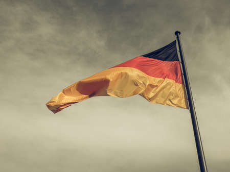 Vintage looking The national German flag of Germany over blue skyの写真素材