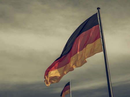 Vintage looking The national German flag of Germany over blue skyの写真素材