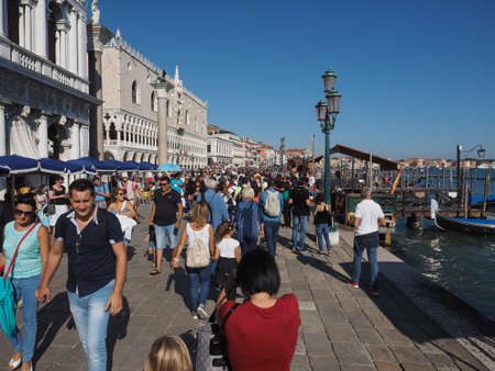 VENICE, ITALY - CIRCA SEPTEMBER 2016: Tourists in Riva degli Schiavoni waterfront promenade at St Mark Basinのeditorial素材
