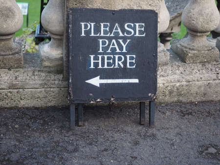 Please pay here sign with direction arrowの写真素材