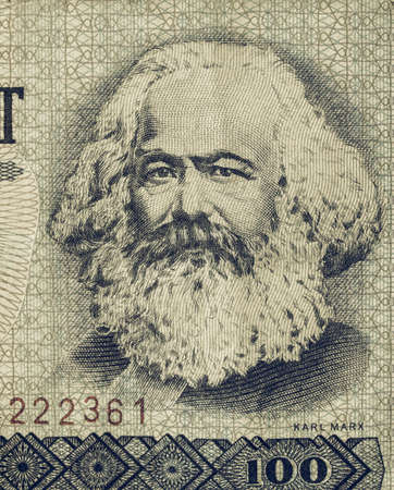 100 Mark banknote from the DDR (East Germany) with Karl Marx with 1 Mark coin - Note: Vintage looking no more in use since german reunification in 1989のeditorial素材