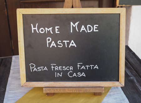 Pasta fresca fatta in casa (meaning Home made pasta) written in English and Italian on a restaurant blackboardの写真素材