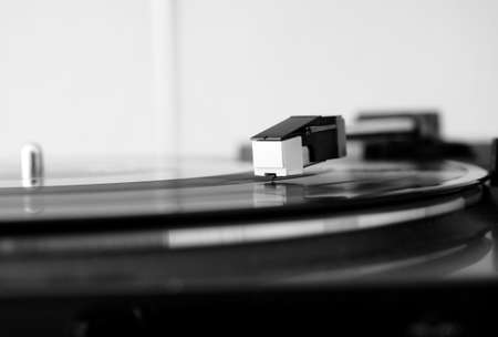 Vinyl record spinning on a turntable, focus on needle - in black and whiteの写真素材