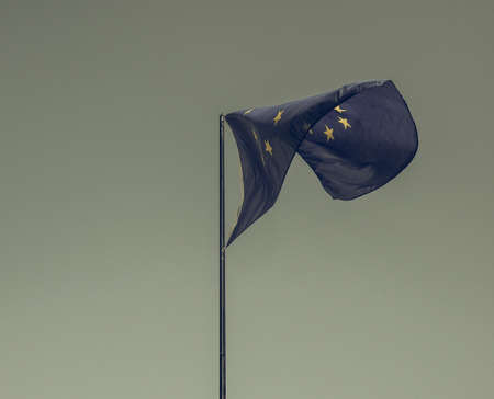 Vintage looking The national flag of European Union floating over blue sky