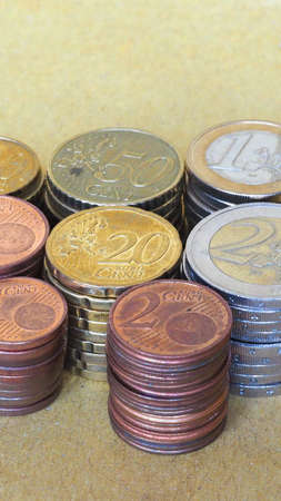 Pile of Euro coins currency of the European Union - selective focus on coins with blurred background copy space - verticalの写真素材